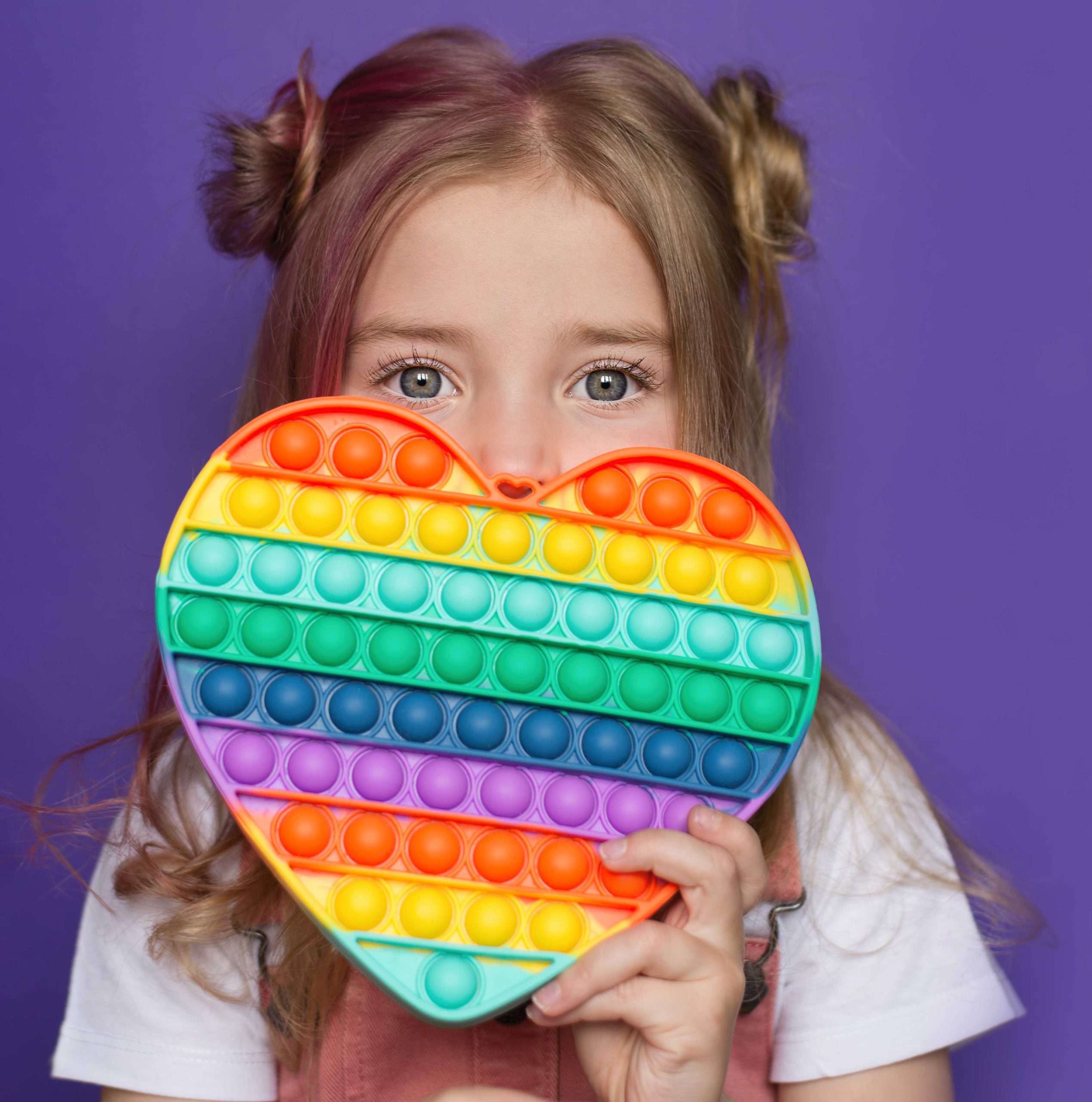a-baby-girl-holds-a-popular-pop-it-toy-in-her-hands