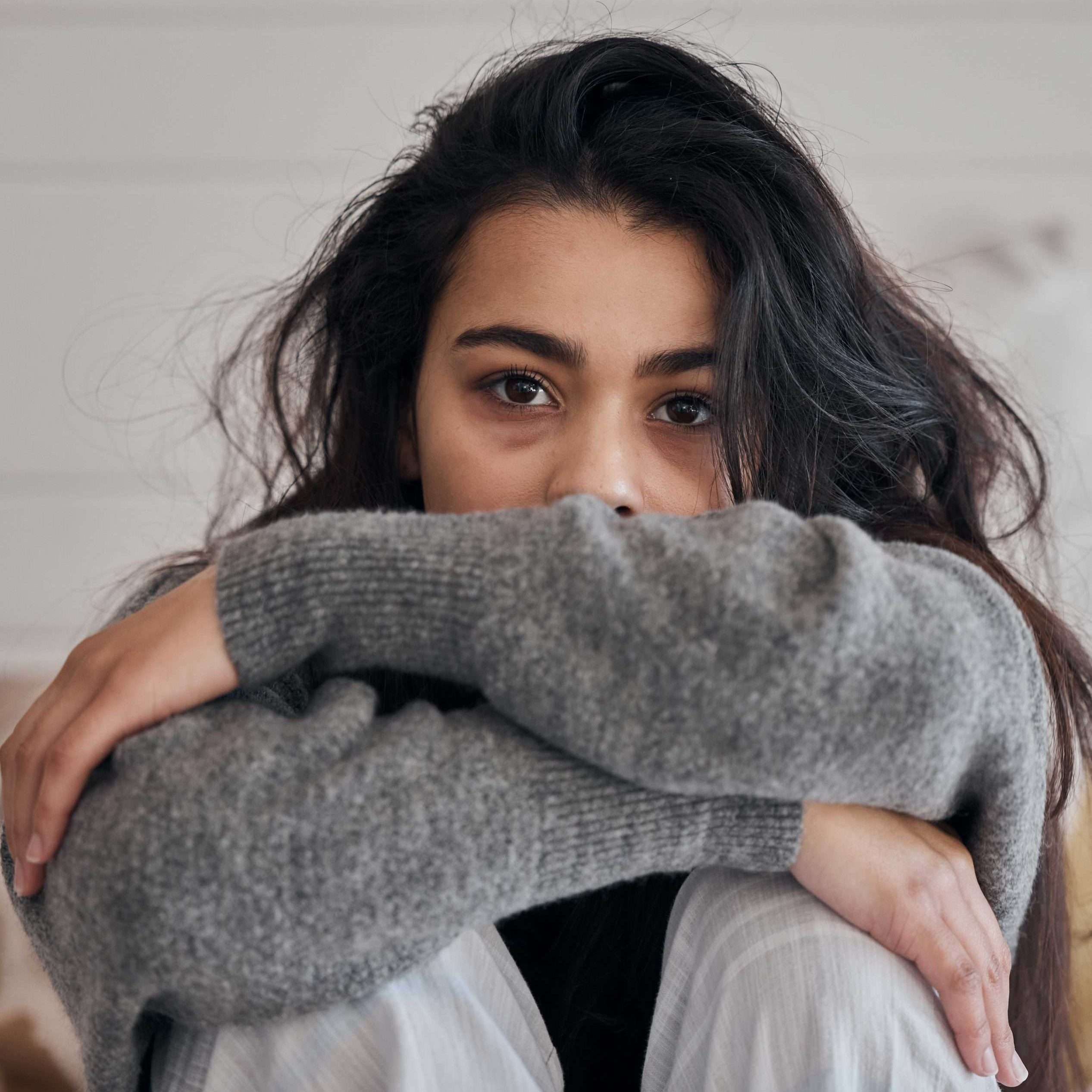 girl staring at camera with arms crossed over knees